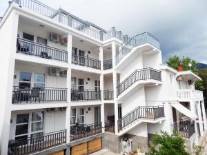un edificio de apartamentos con balcones y mesas en Apartmani "Nebo", en Sutomore