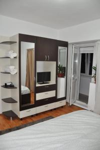 um quarto com um grande centro de entretenimento com uma televisão em Mario Apartments em Reşiţa