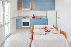 a kitchen with blue cabinets and a table with food on it at Apartments Majić in Hvar