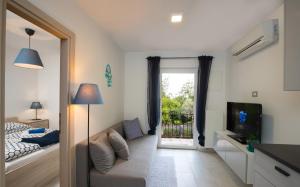 a small living room with a couch and a television at Apartments Beni in Matulji