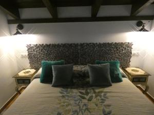 a bedroom with a bed with pillows on it at Lagar II con Jacuzzi in Curiel de Duero