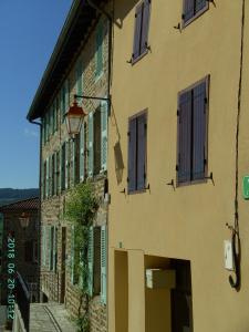 un edificio con finestre con persiane verdi e una strada di La Fontaine a Saint-Georges-en-Couzan