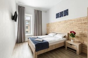 a bedroom with a bed and a brick wall at Nomera na Nevskom 111 in Saint Petersburg