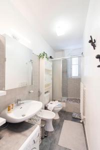 - une salle de bains blanche avec 2 toilettes et un lavabo dans l'établissement Veeve - Contemporary in Balard, à Paris