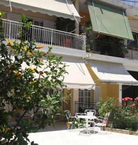 a patio with tables and chairs in front of a building at Family house in Kalamata