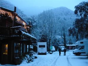 a snow covered street with people walking in the snow at Queenstown Holiday Park Creeksyde in Queenstown