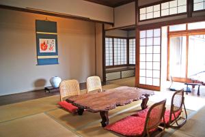 a dining room with a wooden table and chairs at Dougoya in Matsuyama