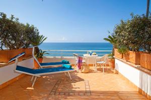 a beach area with chairs, tables and umbrellas at Hotel Il Cefalo in Castellabate