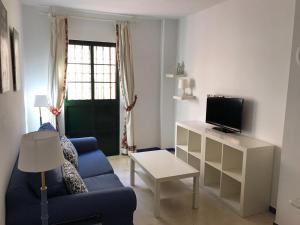 a living room with a blue couch and a tv at CLB Apartamento Alameda in Seville