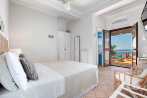 a bedroom with a bed and a view of the ocean at Il Cefalo Hotel & Restaurant in Castellabate