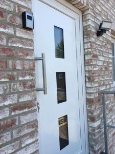 a white door on a brick wall at Ferienhaus Merzijana in Büsum