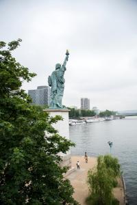 a statue of liberty standing next to a body of water at Veeve - Apartment near Pont de Grenelle in Paris