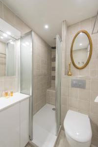 a bathroom with a shower and a toilet and a mirror at Veeve - Apartment near Pont de Grenelle in Paris