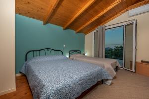 a bedroom with two beds and a large window at Villa Antonio in Romírion