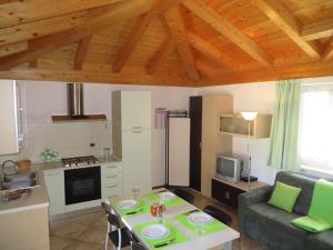 uma cozinha e sala de estar com uma mesa e um sofá em Bella Villa Apartments em Riva del Garda