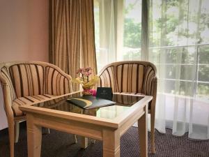 a table and two chairs with a book and flowers on it at Hotel OTDIH in Kavarna +11 photos