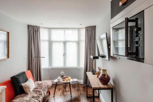 a living room with a couch and a table at The Knaresborough by Nestor in London