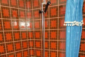 una ducha con cabezal de ducha en una pared de azulejos en Studio Brisiblick - CharmingStay, en Flumserberg
