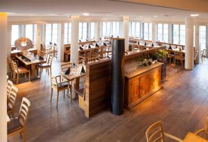 ein Restaurant mit Holztischen und -stühlen und einer Bar in der Unterkunft Hotel Nepomuk in Bamberg
