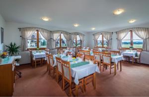 a dining room with tables and chairs and windows at Maravar - Pivný Wellness Adult Friendly in Liptovský Trnovec