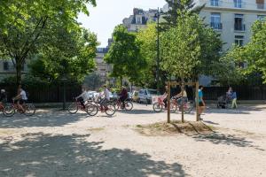 パリにあるVeeve - Avenue to the Eiffel Towerの木の周りを自転車に乗る人々