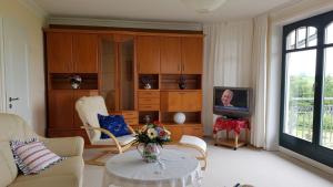 sala de estar con sofá y TV en Ferienwohnung "Am Grün" en Zweedorf