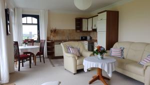 a living room with two couches and a kitchen at Ferienwohnung "Am Grün" in Zweedorf