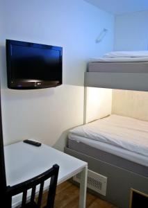 a small room with a bed and a tv on the wall at Hotell Centralstation in Uppsala