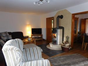 a living room with a wood stove in a living room at Ferienhaus Rabenhorst in Bad Berleburg