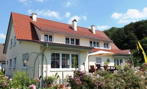 Casa blanca con techo rojo en Pension Waldblick, en Illertissen