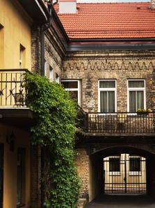 un edificio de ladrillo con un arco y un balcón en Guoda Apartments, en Vilna
