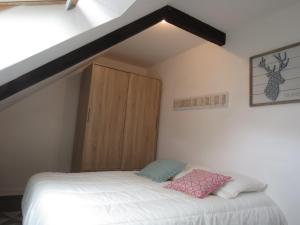 パンポルにあるBel appartement paimpolのベッドルーム1室(ベッド1台付)、木製キャビネットが備わります。