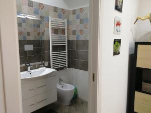 ein Bad mit einem Waschbecken und einem Spiegel in der Unterkunft Maison Lumière in Salerno