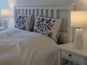ホルベックにあるLabaek B&Bのベッドルーム1室(白いベッド1台、枕、ランプ2つ付)