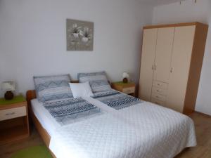 a bedroom with a white bed and a cabinet at Apartments Toni, Borik in Zadar