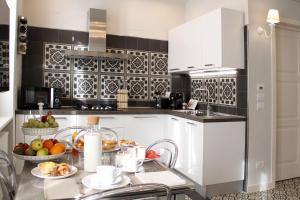 a kitchen with white cabinets and a table with fruits at - Home Sweet Langhe - Room 51 in Alba