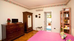 ein Schlafzimmer mit einem rosa Bett und einer Kommode in der Unterkunft Casa 12 B&B in Neapel