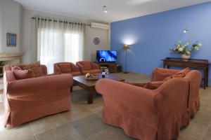 a living room with two couches and a tv at Istron Maisonettes with private pool in Istron