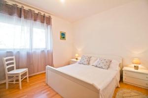 1 dormitorio con 1 cama, 1 silla y 1 ventana en House Ksenija en Gornje Sitno