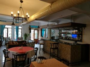 a restaurant with tables and chairs and a bar at Setenay otel in Ayvalık