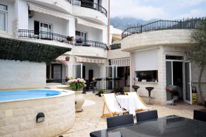 a courtyard with a swimming pool and a house at Monte Perla Residence in Sveti Stefan