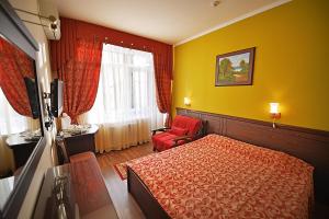 1 dormitorio con 1 cama, 1 silla y 1 ventana en Katran Hotel, en Lazarevskoye