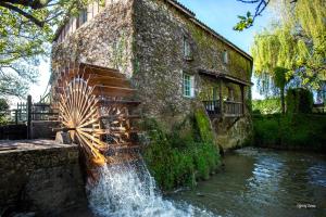 einem Brunnen vor einem Steingebäude in der Unterkunft Moulin de Cocussotte in Saint-Pierre-sur-Dropt