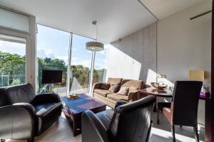 a living room with leather furniture and a large window at Apart residences by the sea in Palanga