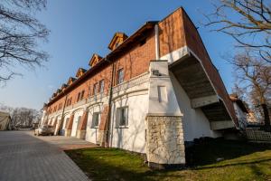 a large brick building with a car parked next to it at Hotel Vinnica in Wieliczka