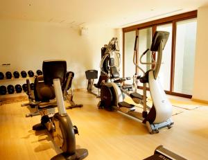 - une salle de sport avec plusieurs tapis de course et vélos d'exercice dans l'établissement Mai Samui Beach Resort & Spa - SHA Plus, à Ban Bang Po