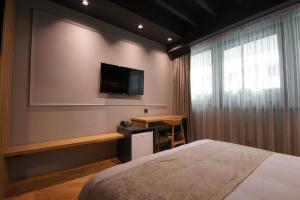a bedroom with a bed and a flat screen tv at Hotel London B&B in Skopje