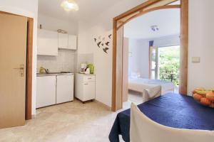 a kitchen and living room with a table and a bed at Apartments Nine Slano in Slano