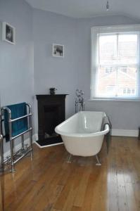 a white bath tub in a room with a fireplace at Beautiful large victorian waterfront house in Bristol