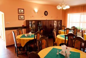 a dining room with two tables with yellow and green table cloth at Pensiunea Vlad in Timişoara